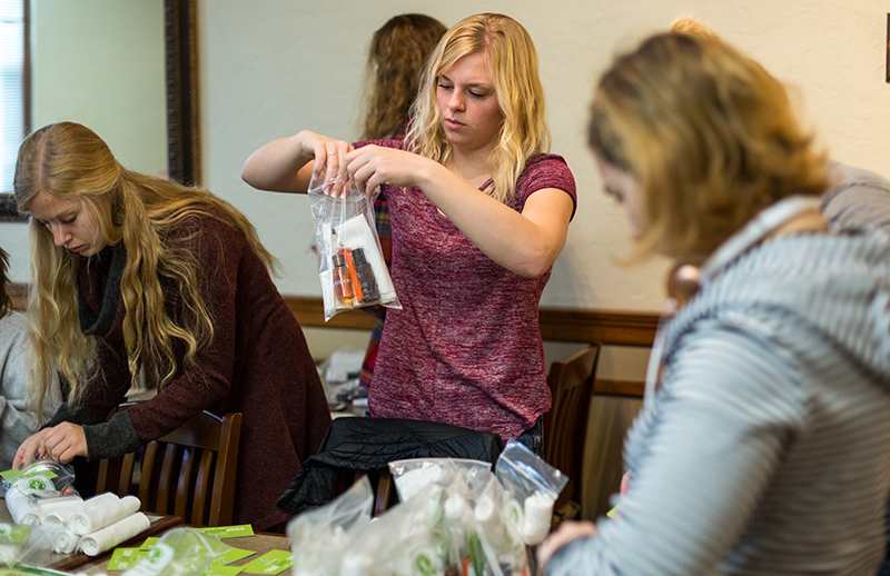 Female students fill plastic bags with hygiene products