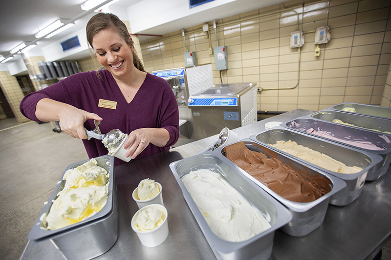 Emory Telios scoops out some sorbet from a selection of flavors.