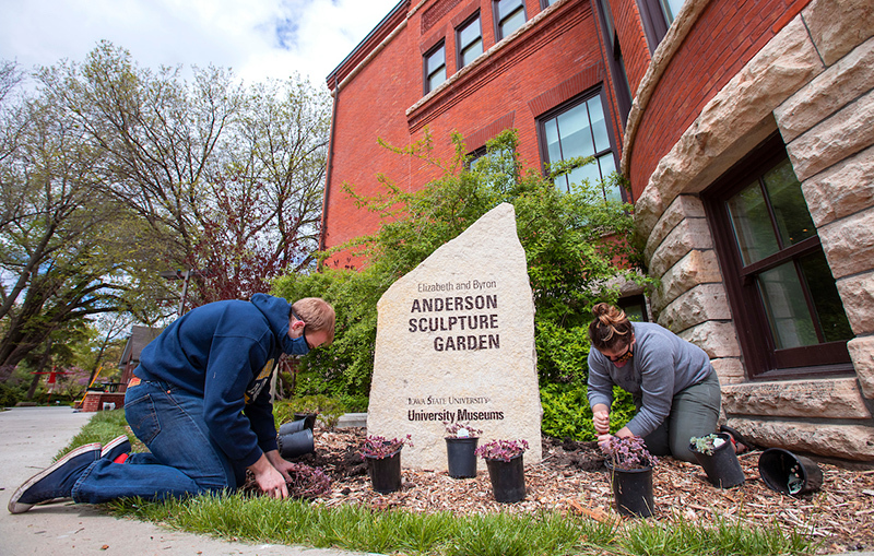 Quinn Vandenberg and Brooke Rogers plant in the sculpture garden