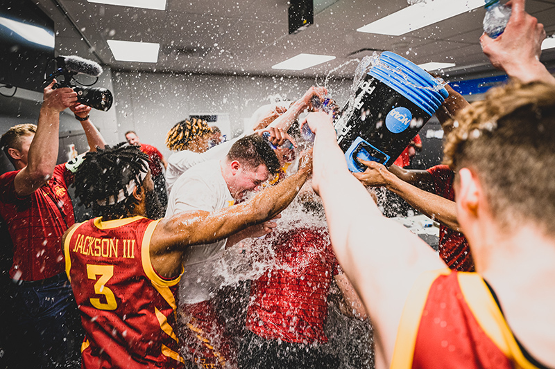 Men's team showers Coach Otzelberger with water in locker room