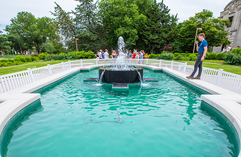 Employee observing fountain efficiency speaks into walkie talkie