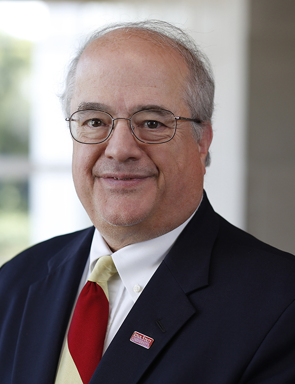 White man in navy blazer, red and gold-striped tie