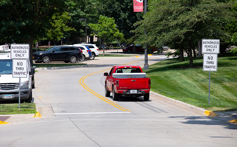 Red university truck drives north on two-directional Morrill Roa