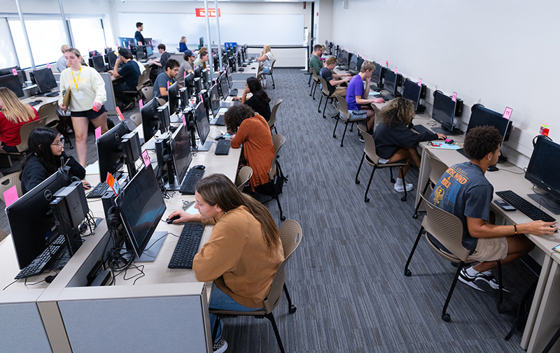 Students in testing center with long tables and no privacy divid