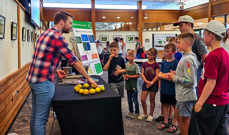 Male with beard explains lemons wired for energy to a group of y