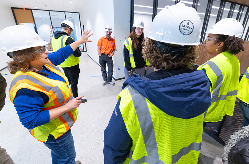 Woman construction manager explains features to group of student