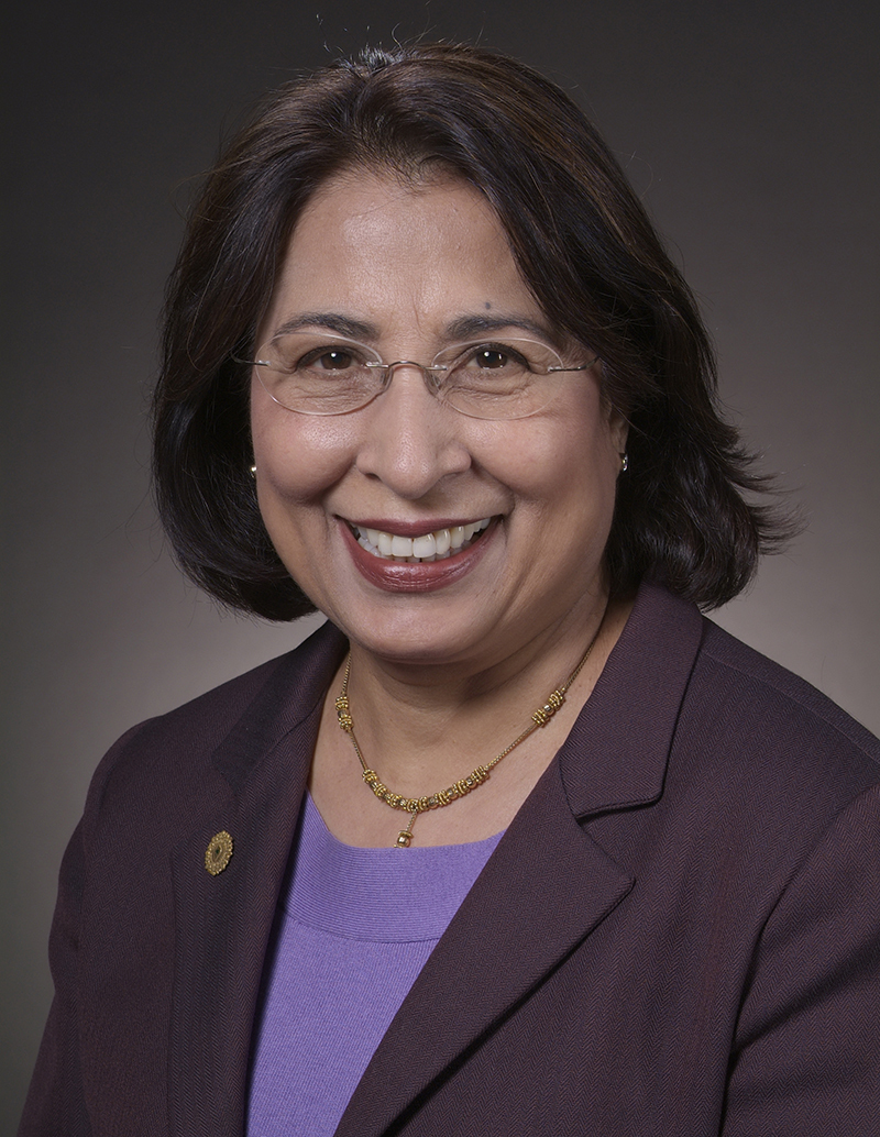 Head shot of Indian woman with glasses in burgandy blazer