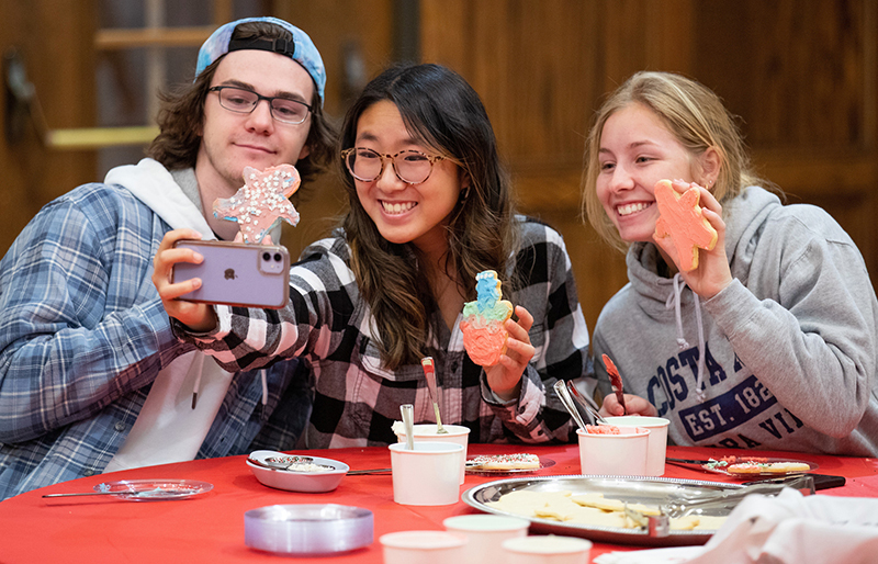 One male and two female students take a selfie photo with froste