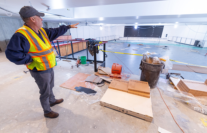 Man in construction vest explains attributes of room under const