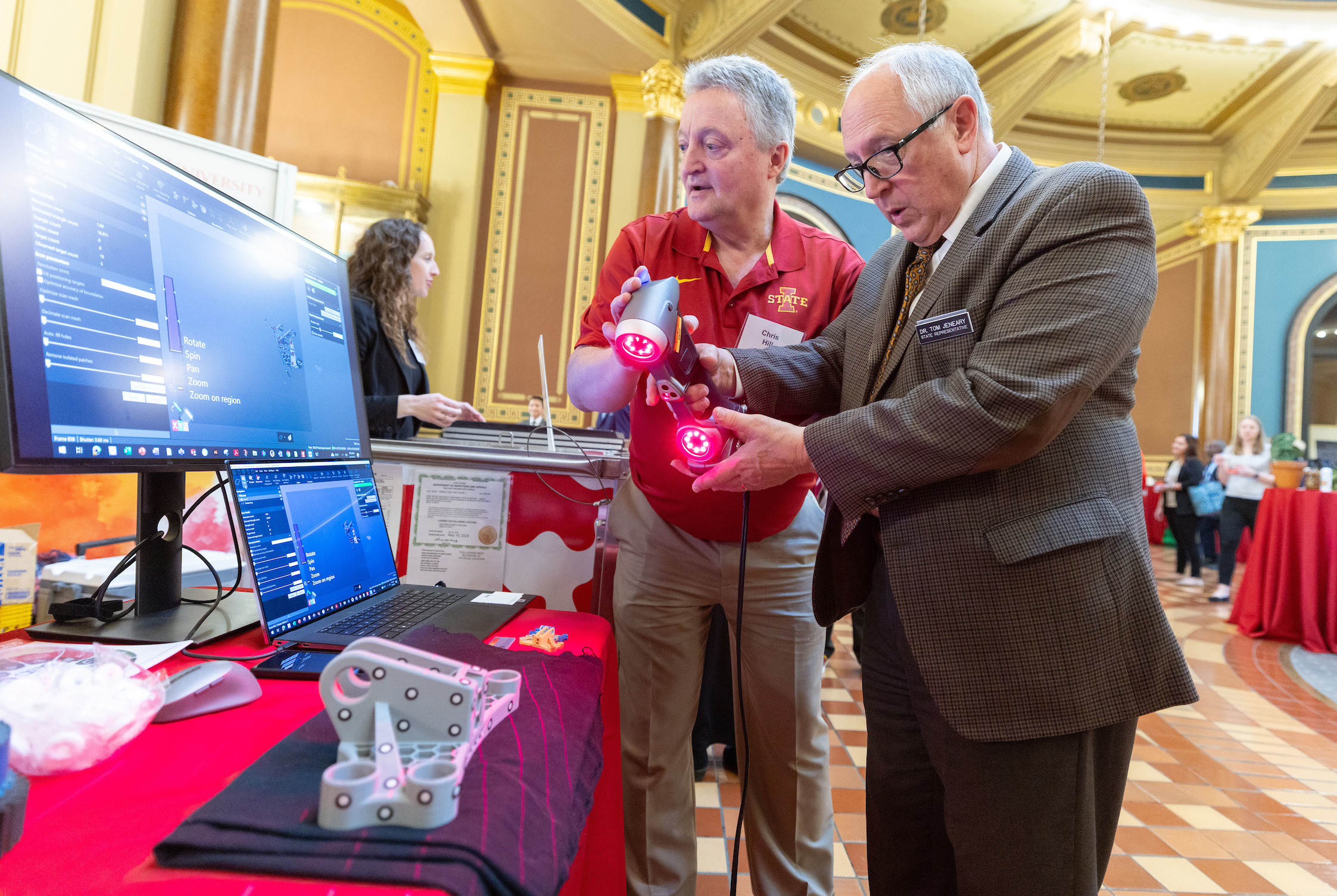 Man in Iowa State shirt demonstrates handheld scanner for legisl